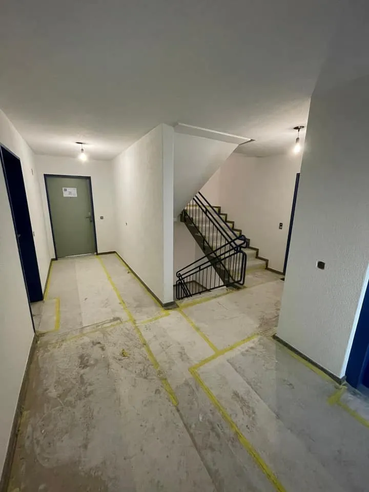Etagenpodest mit Wohnungstüren und neu gestrichenen Wänden.