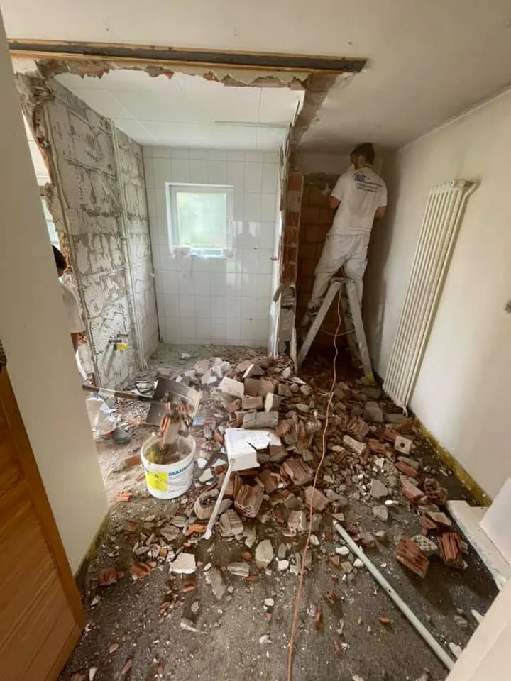 Abbruch einer Wand im Bad mit Schutt am Boden.