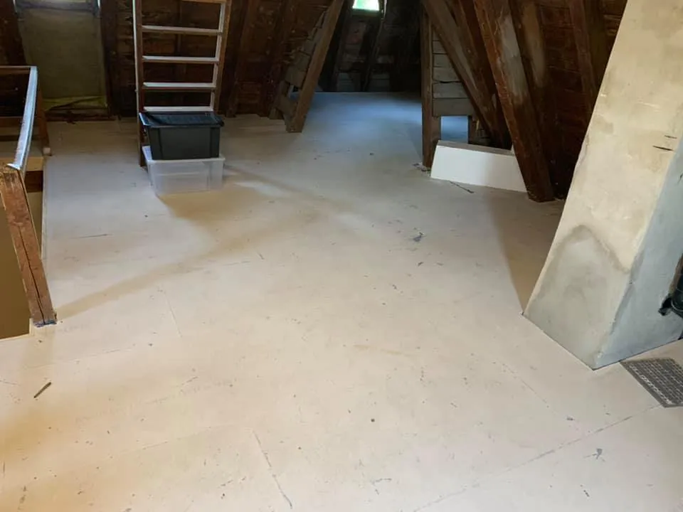 Ausgeräumter Dachraum mit alten Holzbalken vor dem Innenausbau.