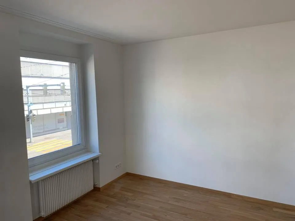 Schlafzimmer mit neuem Parkettboden und glatten, weissen Wandflächen.