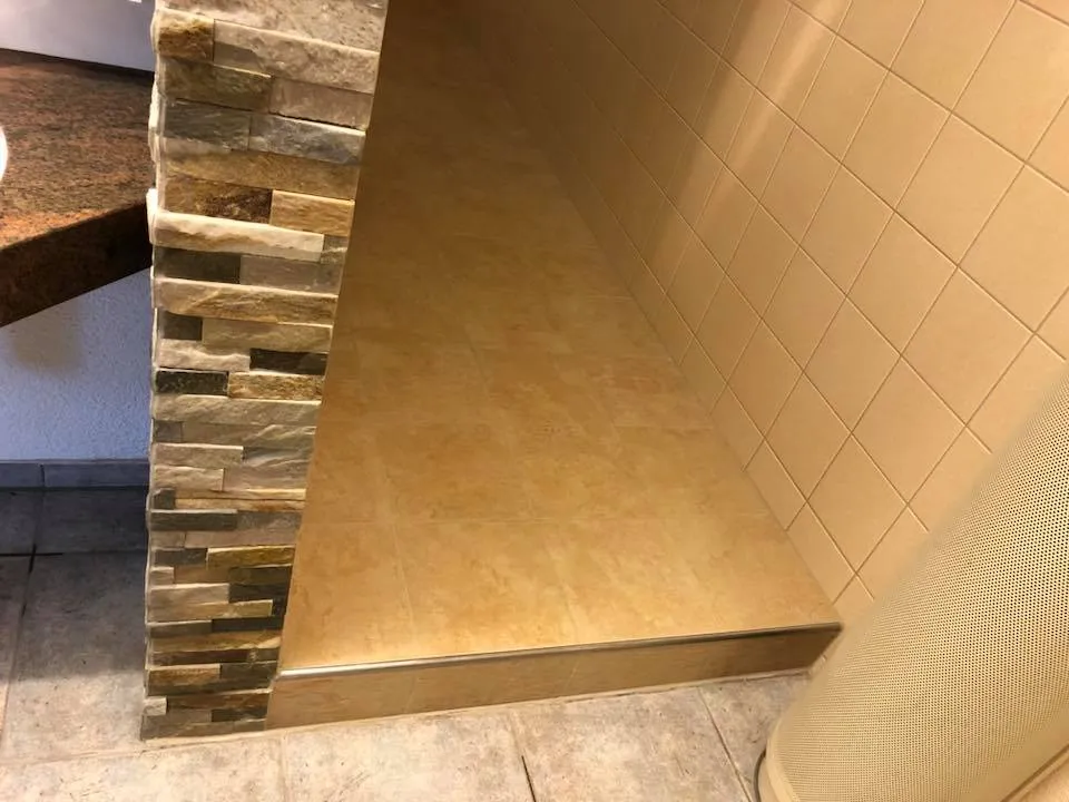 Übergang zum Duschbereich mit Natursteinriemchen und neuen Bodenplatten.