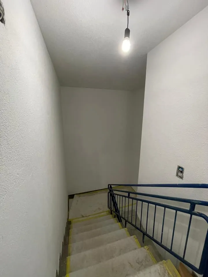 Treppenabgang mit hellen Wänden nach dem Neuanstrich.