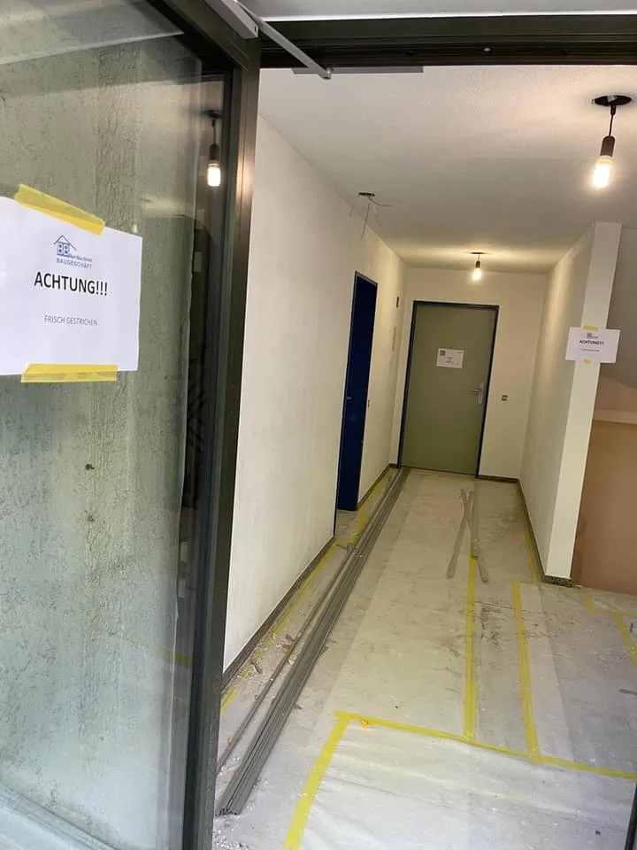 Korridor zu den Wohnungen mit frischem Anstrich und abgedecktem Boden.