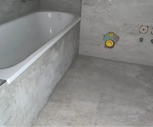 Neu geplattetes Bad mit eingebauter Wanne vor der Sanitärmontage.