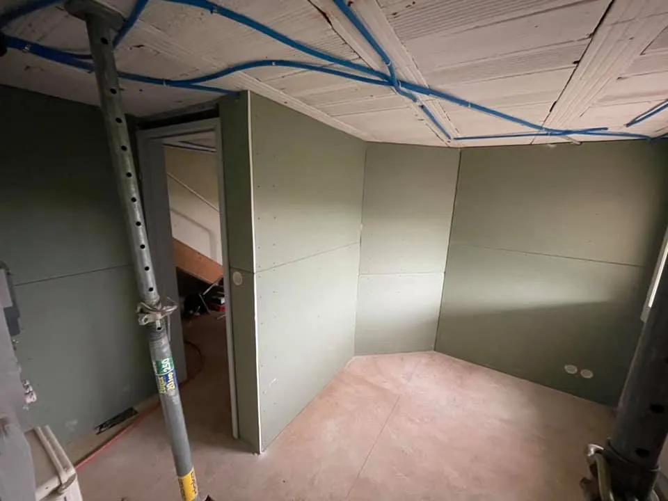 Neue Trennwände aus Gipsplatten mit Türöffnung im Rohbau.
