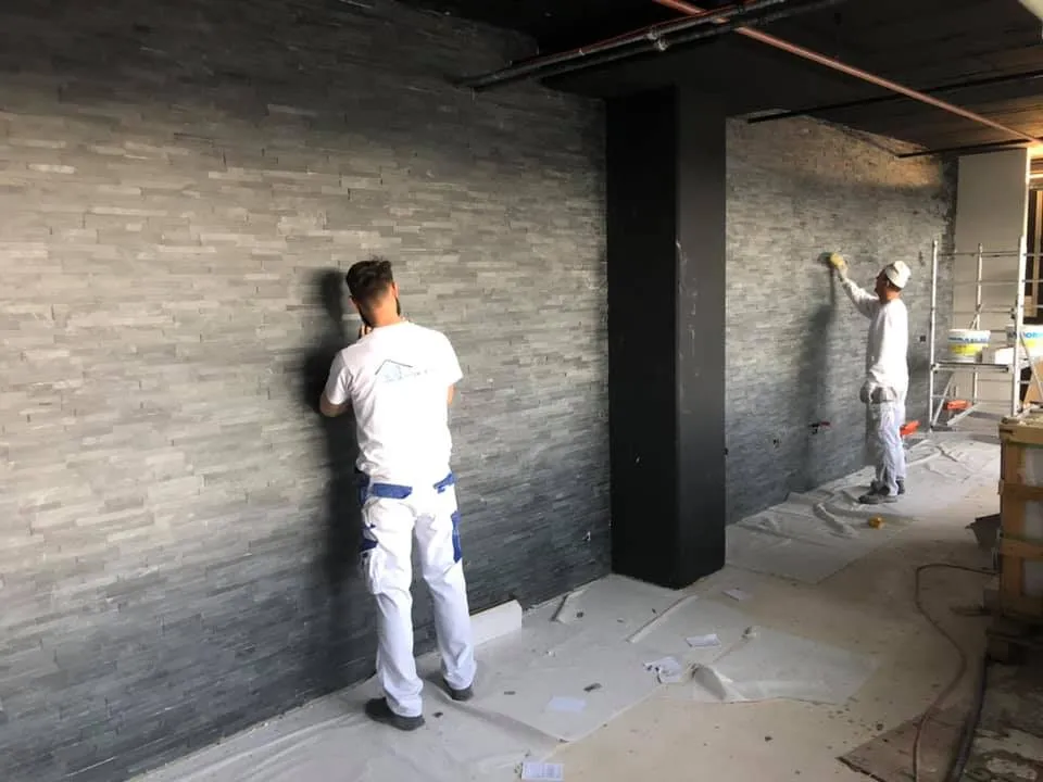 Verfugen und Reinigen der Natursteinwand während der Ausführung.