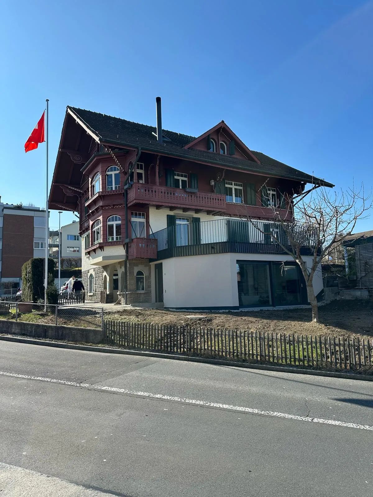 Villa nach der Sanierung mit fertig verputztem Anbau und Terrasse.