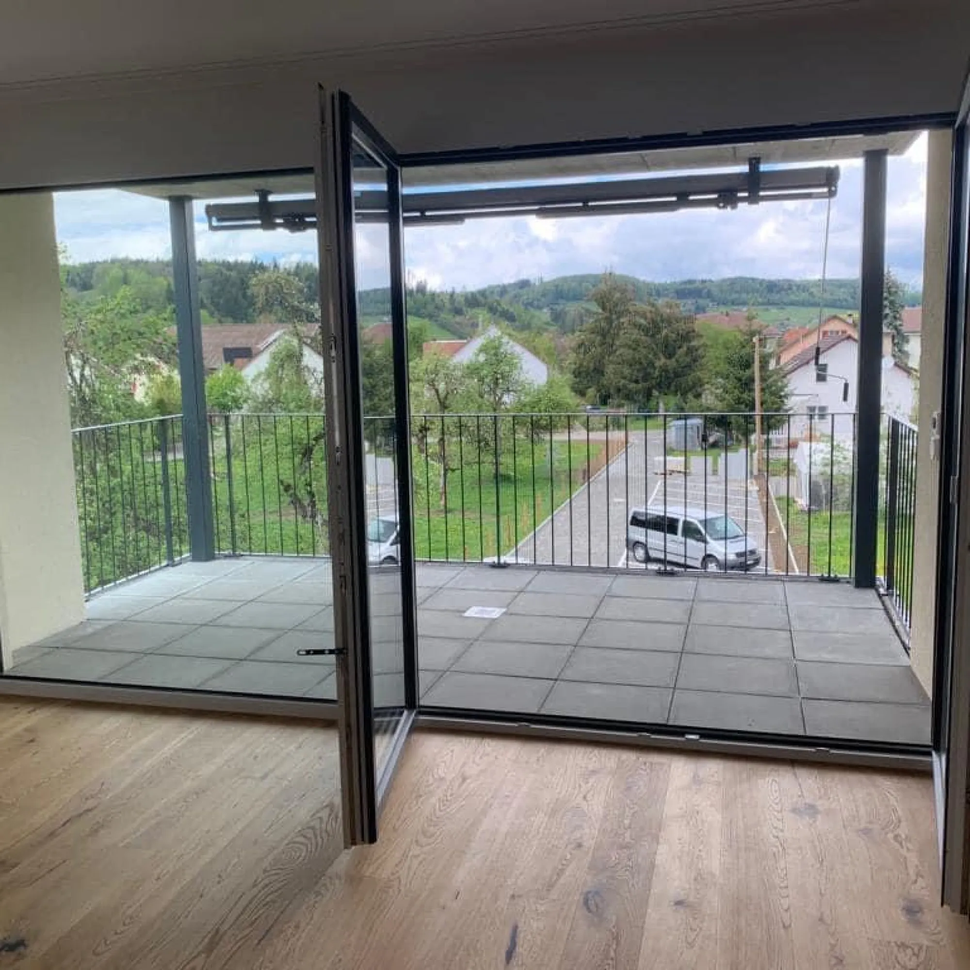 Wohnraum mit Parkett und Zugang zur neu belegten Terrasse.