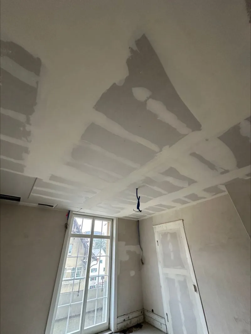 Raum mit gespachtelter Decke und Wänden vor dem Schleifen.