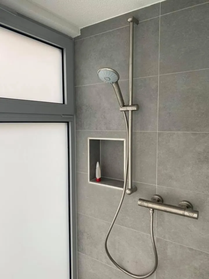 Dusche mit grossformatigen Wandplatten und eingelassener Nische.