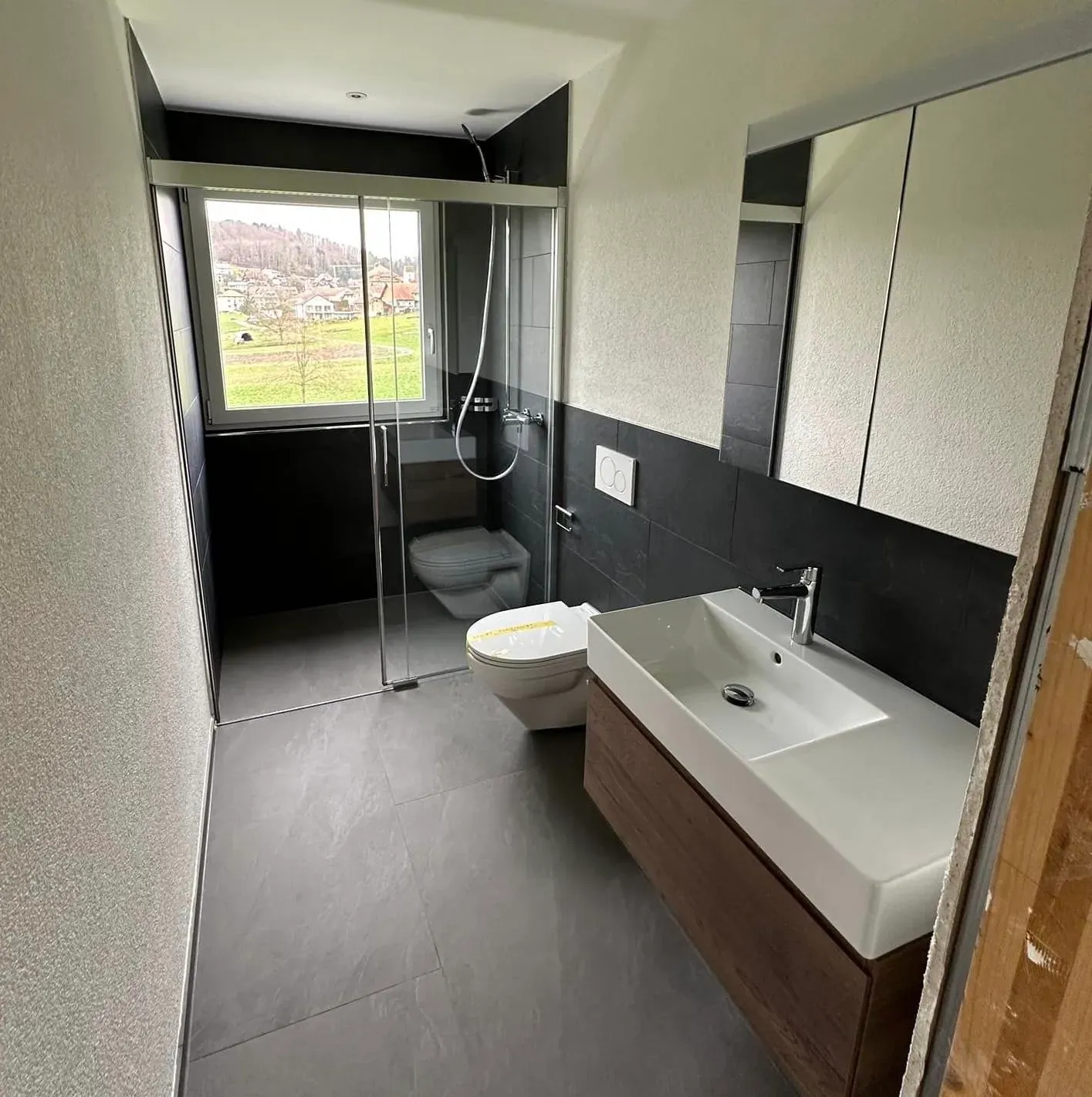 Fertig renoviertes Badezimmer mit grossformatigen Platten und Walk-in-Dusche