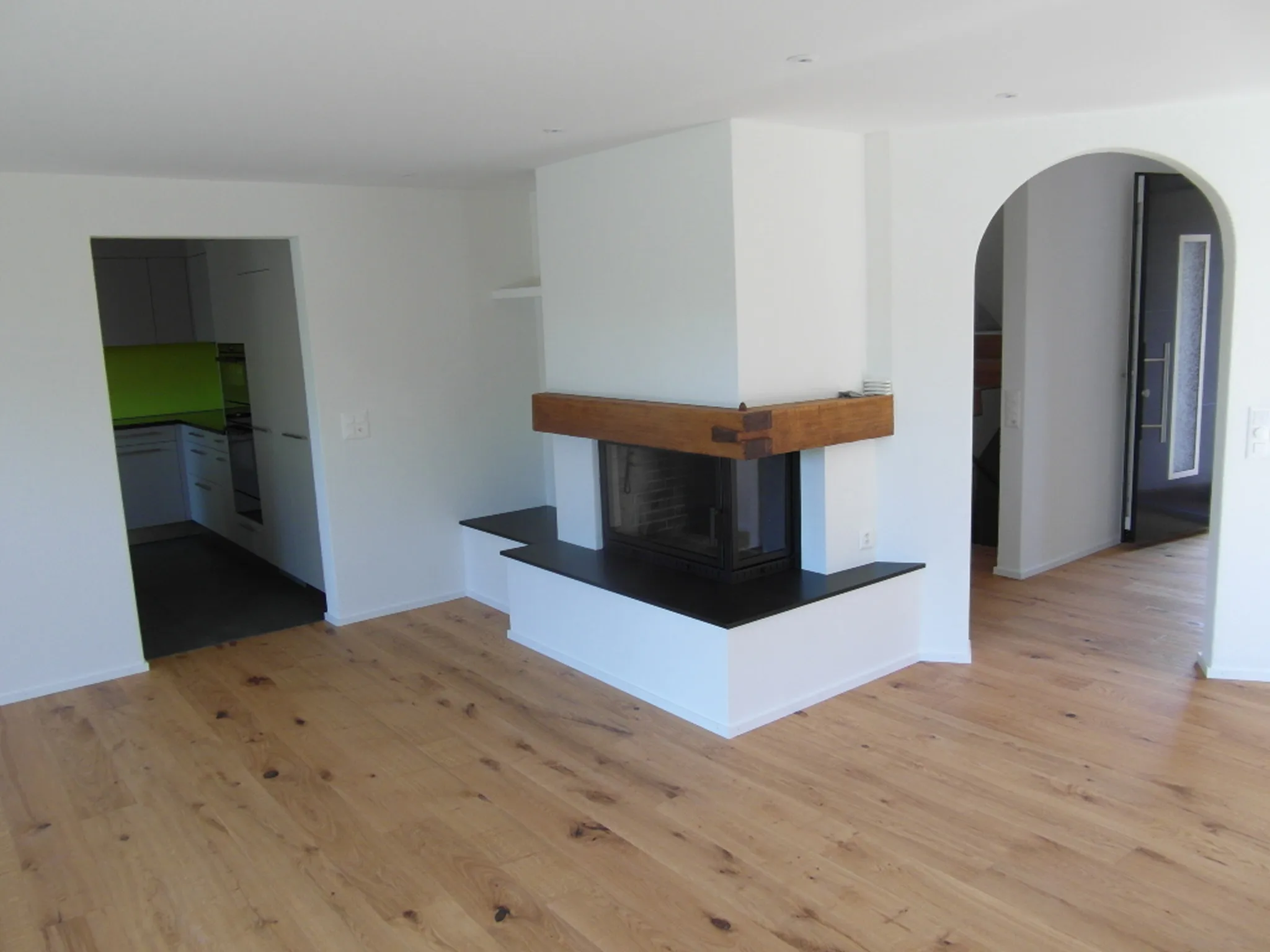 Frisch gestrichener Wohnraum mit Cheminée und Holzboden